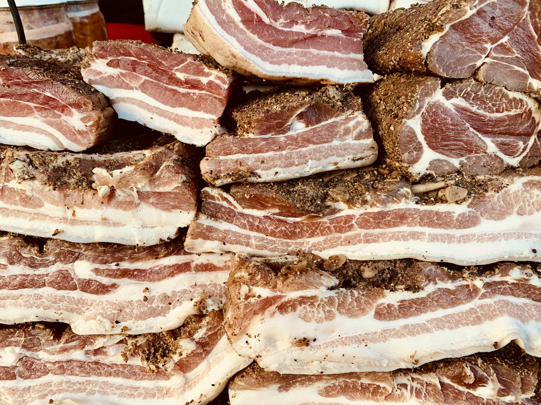 High-quality image of stacked raw pork belly slices, seasoned and ready for cooking.